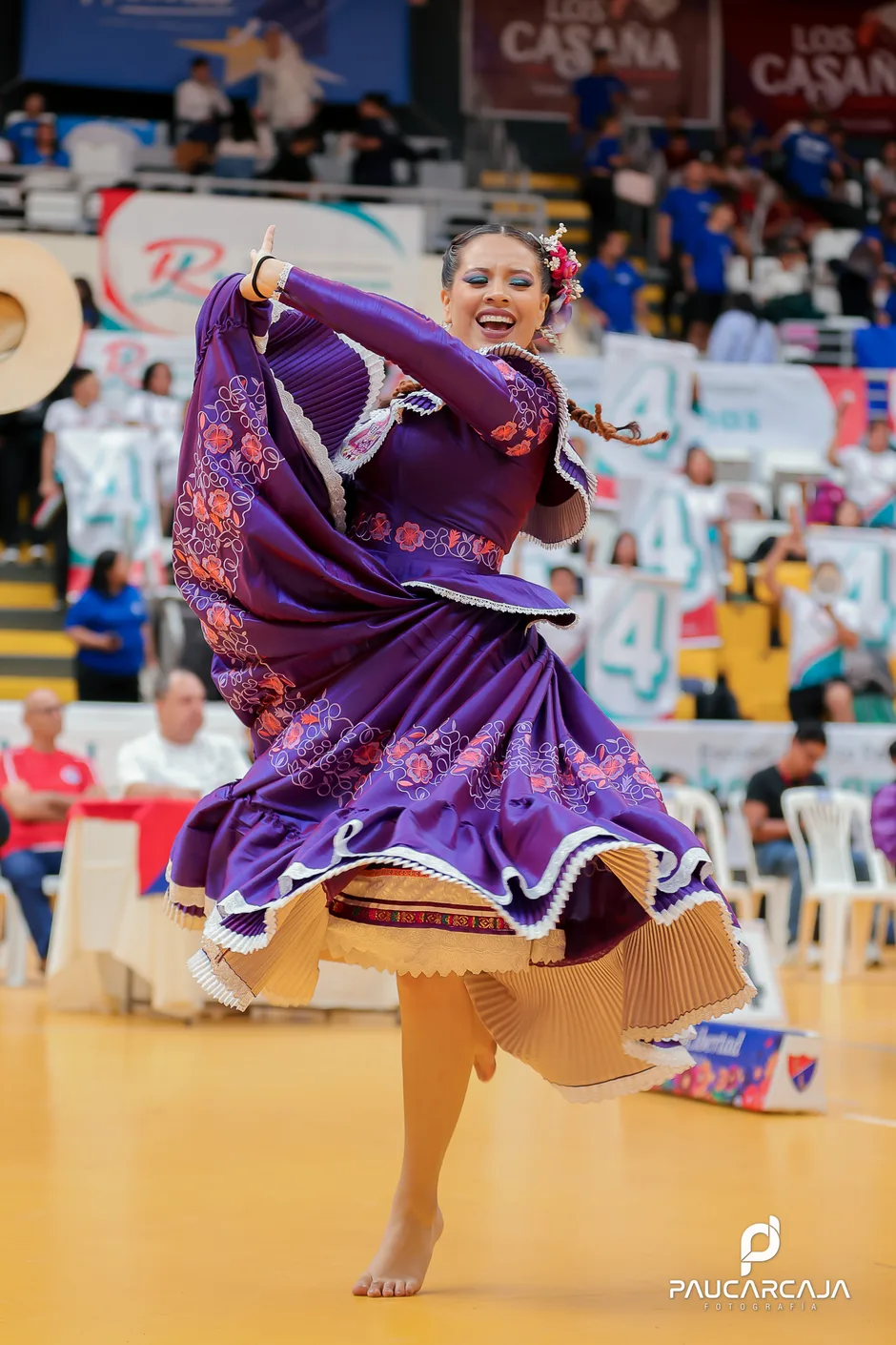 Bailarina de marinera en salto con falda morada bordada
